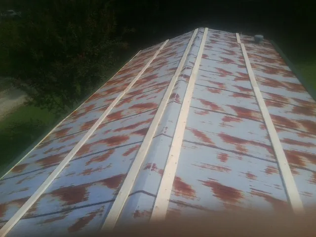 Rusted metal roof panels with new wood purlins before replacement — Storm Damage Roof Repair in Hot Springs Village by Roofing Brothers
