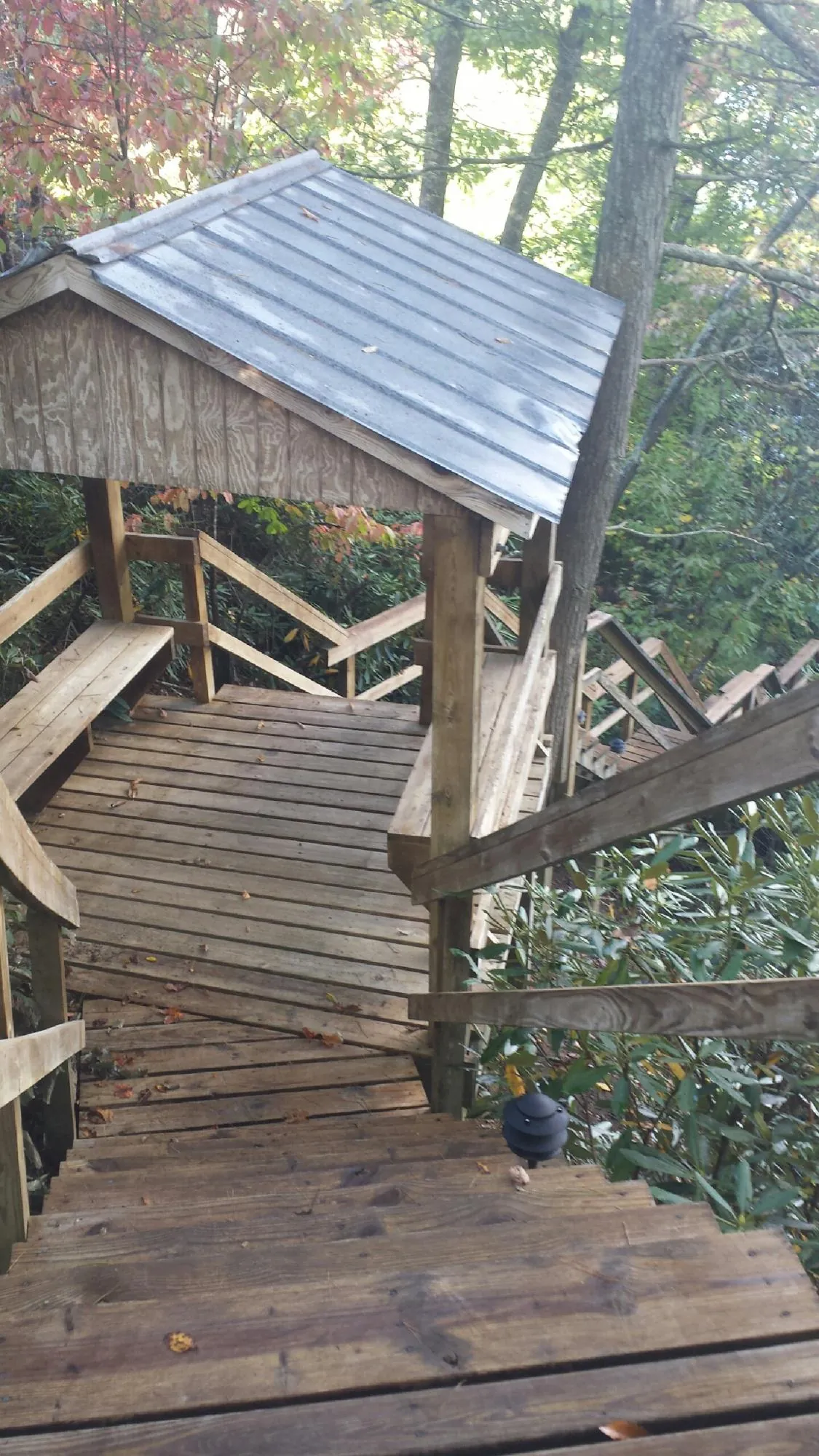Metal roofed shelter over wooden steps on a wooded walkway — Skylight Repair & Installation work by our crew in Hot Springs Village