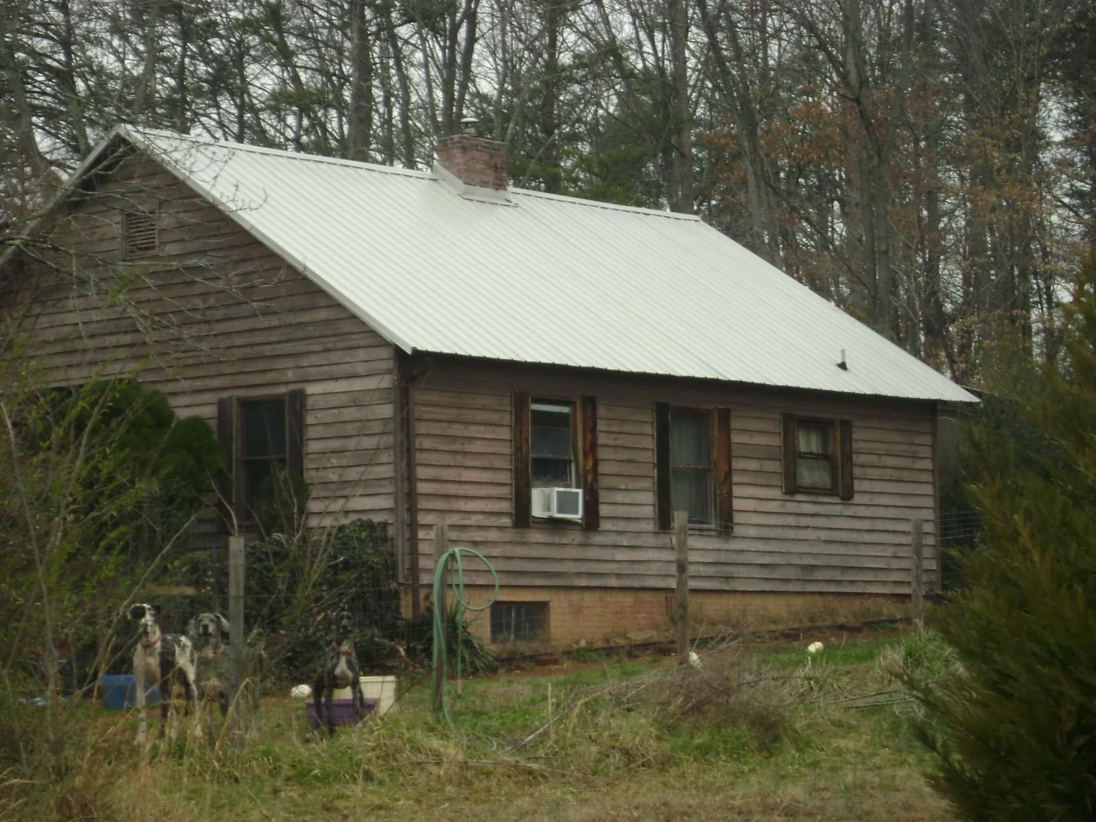 White metal roof on an old wood sided farmhouse, from a Metal Roof Installation job in Hot Springs Village